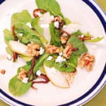 Arugula salad with caramelized onions, brown sugar walnuts, pears, and crumbled Gorgonzola cheese