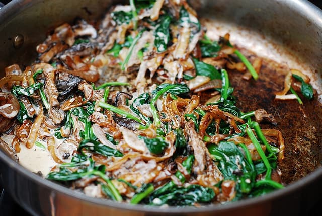 cooking mushrooms, caramelized onions, and spinach