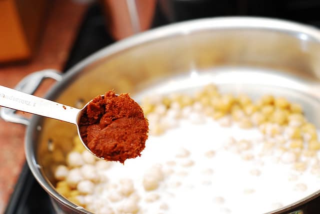 Adding red curry paste to chickpeas and coconut milk