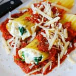 stuffed manicotti pasta shells with ricotta cheese and spinach filling in tomato sauce