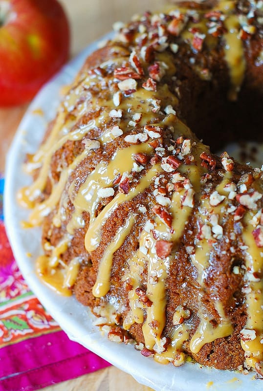 Apple Pumpkin Bundt Cake with Caramel Drizzle and Chopped Pecans on a white plate