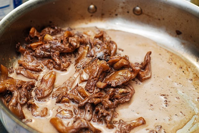 add heavy cream to mushrooms cooked in a red wine in a large skillet