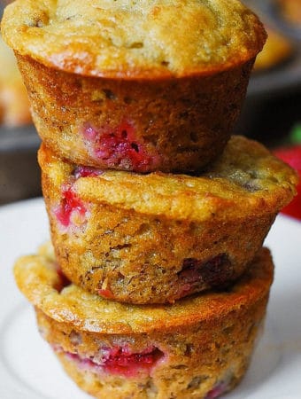 3 strawberry banana bread muffins stacked on top of each other on a white plate