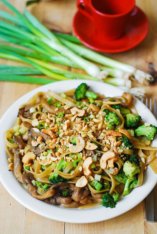 Asian-flavored pasta with broccoli and oyster mushrooms, topped with cashew nuts