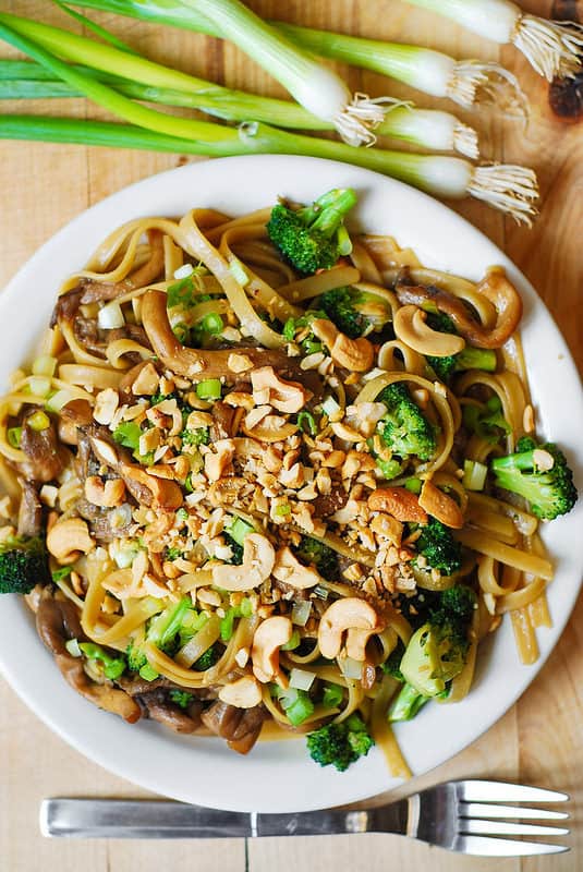 Asian-flavored pasta with broccoli and oyster mushrooms, topped with cashew nuts