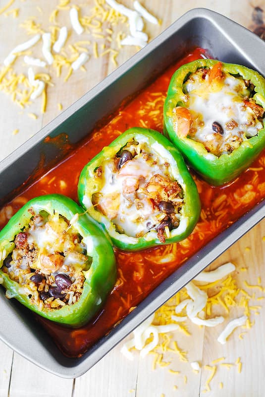 bake stuffed bell peppers in tomato sauce with cheese (process shot)
