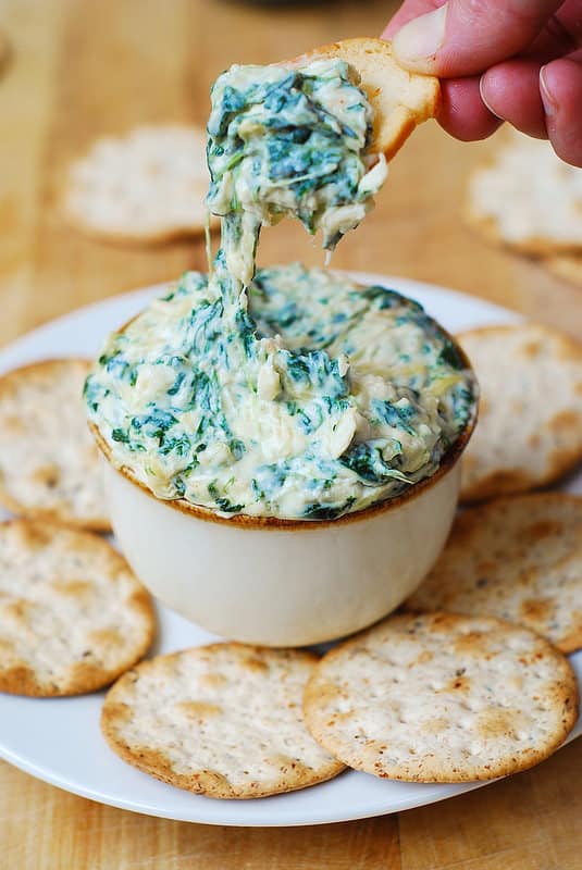 dipping the cracker in the spinach and spaghetti squash dip