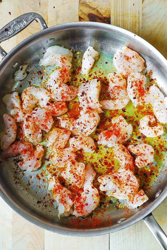 cooking shrimp, sprinkle the top of shrimp with crushed red pepper, paprika and salt to cover every single shrimp