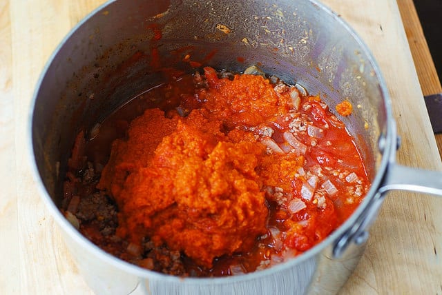 Adding pureed pumpkin to the beef, onions, and garlic - pumpkin chili (process shot)