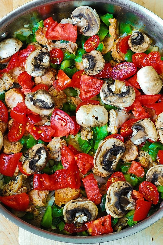 adding mushrooms to the pasta skillet with vegetables