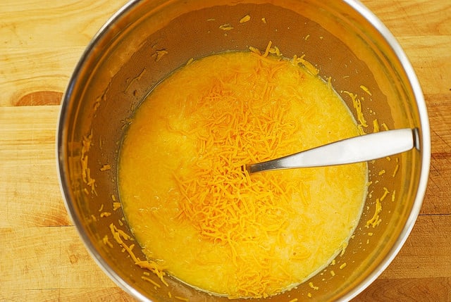 mixing eggs and cheddar cheese (process shot)