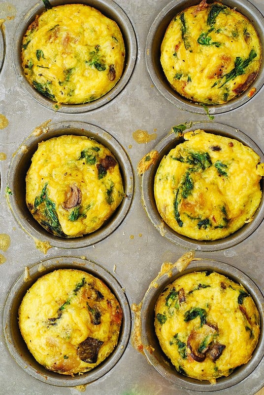 breakfast egg muffins with spinach and mushrooms in a muffin pan