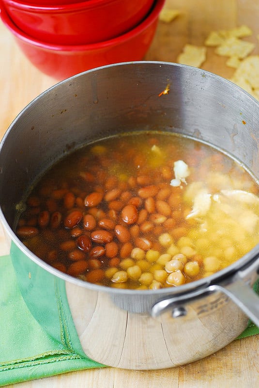 adding pinto beans, garbanzo beans to the chicken (process shot)