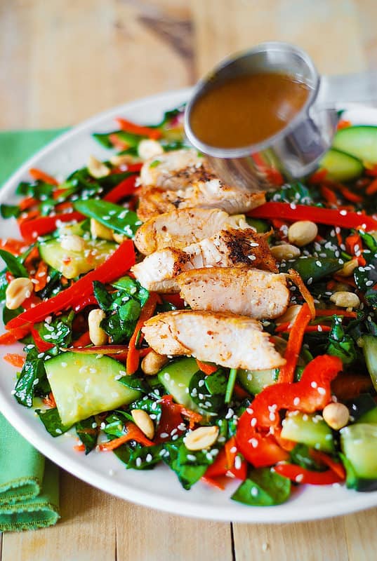 Crunchy Asian Salad with chicken, spinach, cucumbers, red bell pepper, carrots, sugar snap peas, toasted peanuts and sesame seeds, and homemade Sesame Peanut Dressing