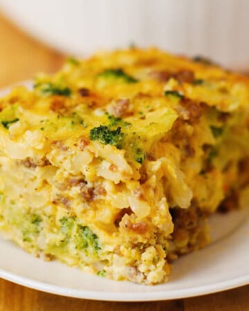 Sausage and Egg Breakfast Casserole with shredded hash brown potatoes, broccoli, cheddar cheese, sausage and eggs (slice of it on a plate).