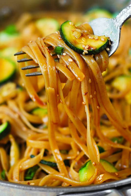 Thai zucchini noodles with red curry paste honey soy sauce and sesame seeds in a large skillet