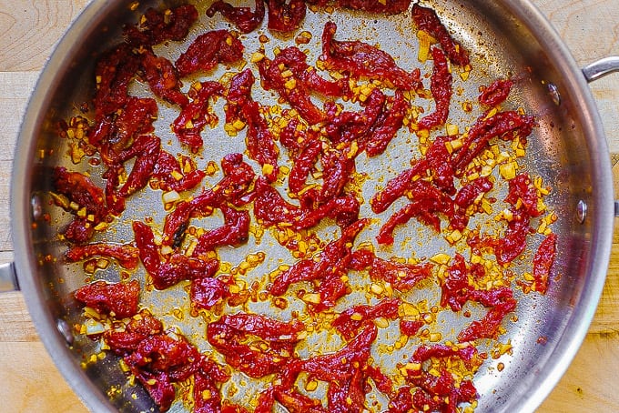 cooking sun-dried tomatoes and garlic in a large skillet