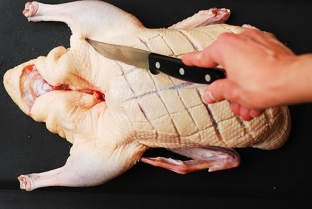 poking the duck's skin with a knife