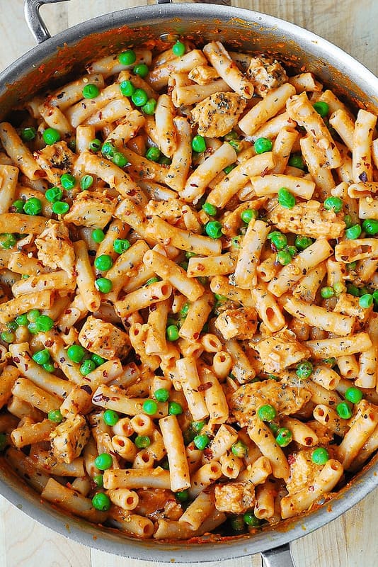 chicken pasta with creamy tomato sauce, peas in a large skillet