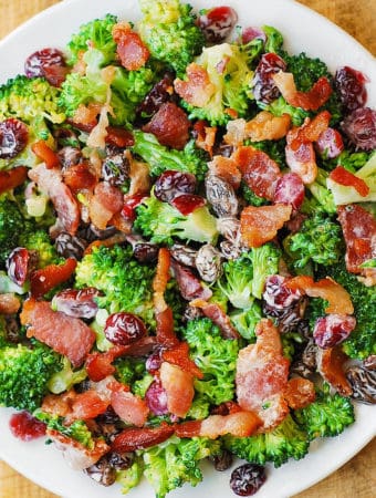 Broccoli Salad with Bacon, Raisins, Dried Cranberries, and Pecans - on a white plate.