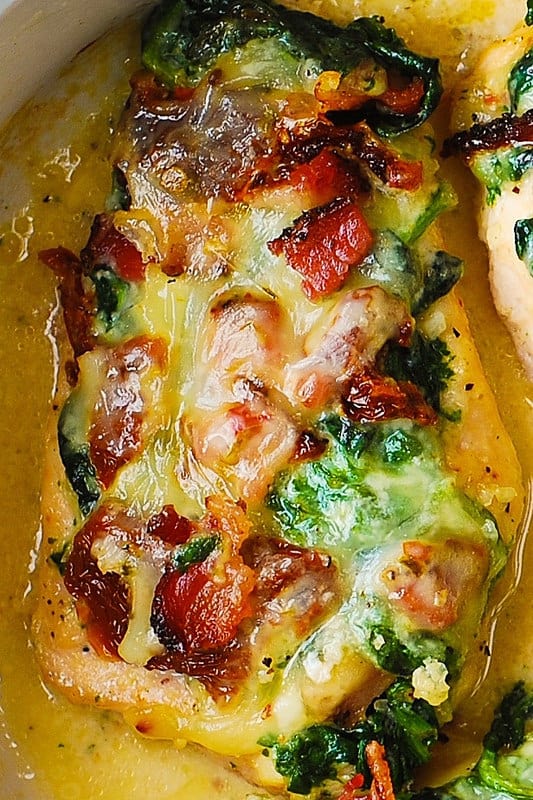 close-up of chicken bake with sun-dried tomatoes, creamed spinach, and bacon