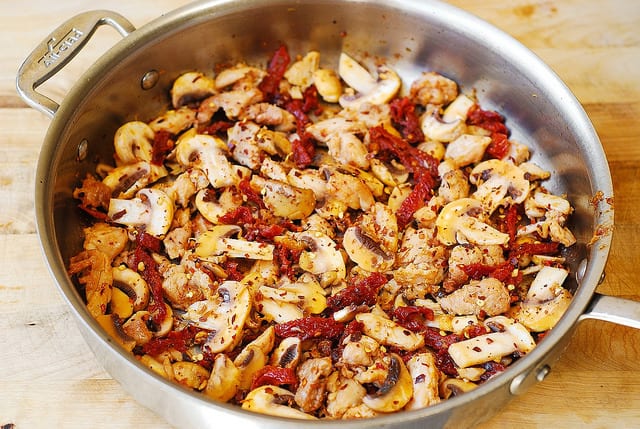 chicken, sun-dried tomatoes, mushrooms with olive oil in a skillet