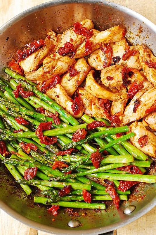 Paprika Chicken, Asparagus, and Sun-Dried Tomatoes - in a stainless steel skillet.