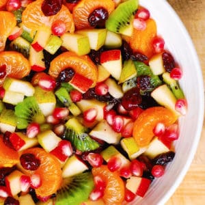 Winter Fruit Salad with Maple-Lime Dressing, with red apples, pears, clementine oranges (or mandarin oranges), kiwi fruit, dried cranberries, and pomegranate seeds