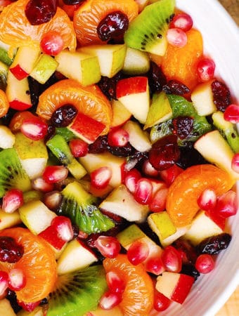 Winter Fruit Salad with Maple-Lime Dressing, with red apples, pears, clementine oranges (or mandarin oranges), kiwi fruit, dried cranberries, and pomegranate seeds