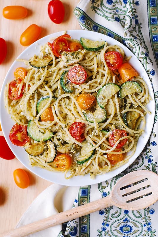 Chicken Spaghetti with Cherry Tomatoes, Zucchini, and Basil Pesto on a white plate