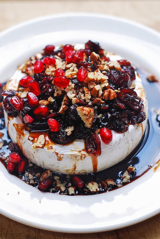 Baked Brie Recipe with Cranberries, Pecans, Pomegranate on a white plate