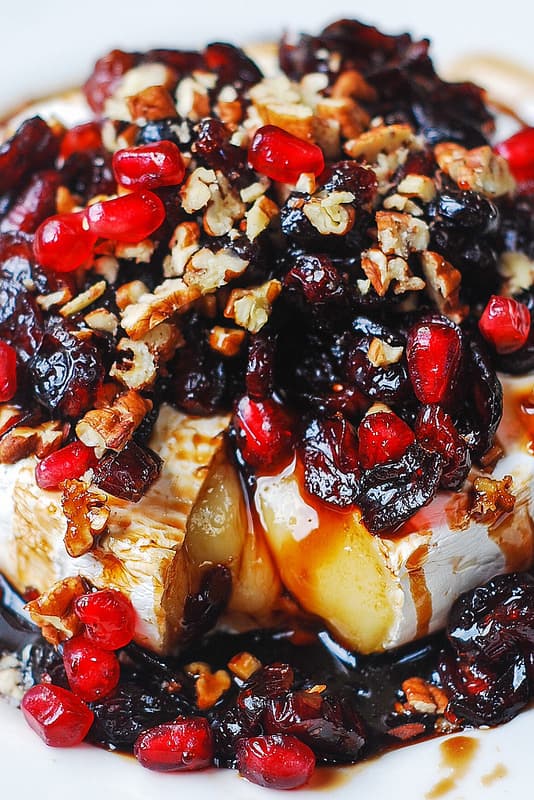 Baked Brie Recipe with Cranberries, Pecans, Pomegranate on a white plate
