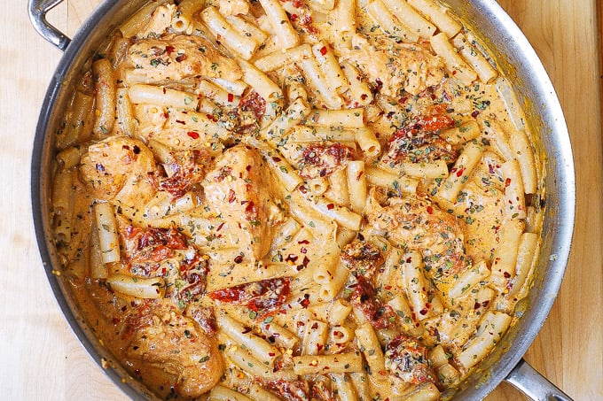 Chicken Mozzarella Pasta with Sun-Dried Tomatoes in a stainless steel skillet