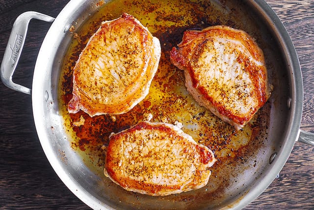 how to sear pork chops in a stainless steel skillet, pork chops seasoned with salt and pepper