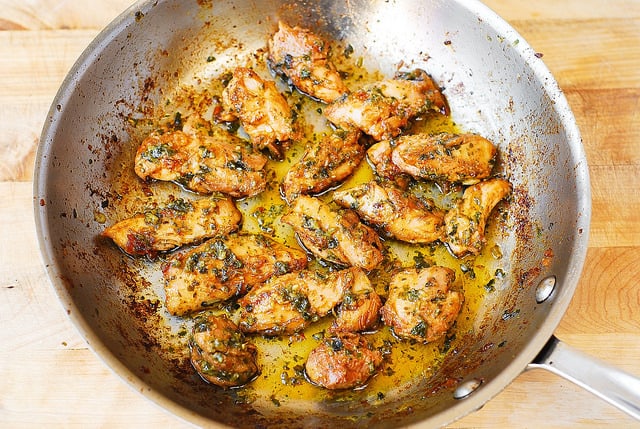 basil pesto chicken in a stainless steel pan