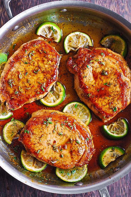 Pan Fried Pork Chops with Honey Lime Glaze - in a stainless steel skillet.