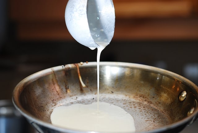 Pouring crepe batter onto the heated frying pan