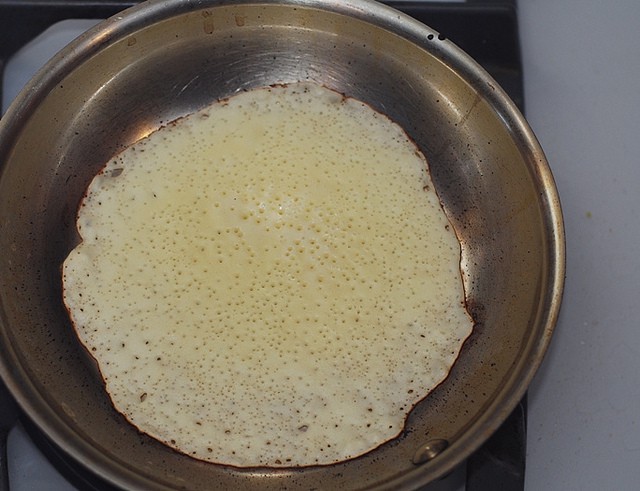 All liquid batter is gone, just nice bubbled side of the crepe is there