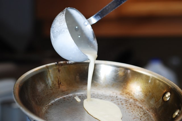 Pouring crepe batter onto the heated frying pan