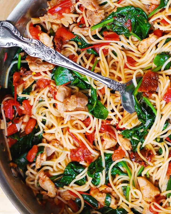 Tomato Spinach Chicken Spaghetti - in a stainless steel pan.