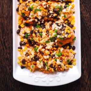 Mexican Street Corn Black Bean Chicken Bake with Cotija Cheese and Red Pepper Flakes on a white plate