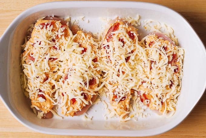 Add shredded Mozzarella cheese over the chicken breasts