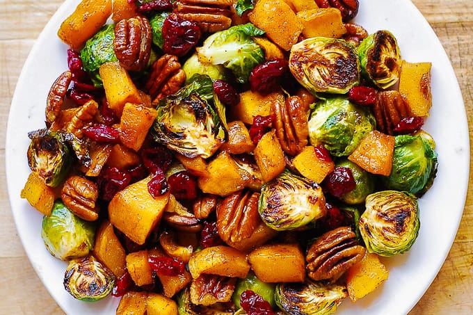 Thanksgiving Brussels sprouts and Butternut Squash with Pecans and Cranberries on a white plate