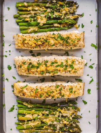 baked halibut and asparagus - on a parchment paper lined baking sheet.