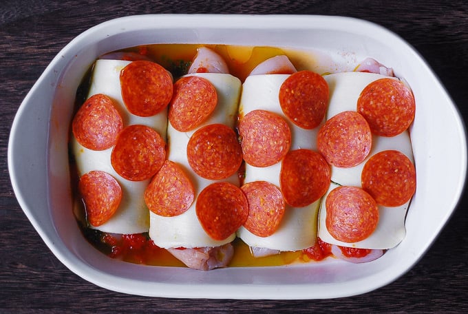 Mozzarella cheese covered chicken breasts with pepperoni in a casserole dish