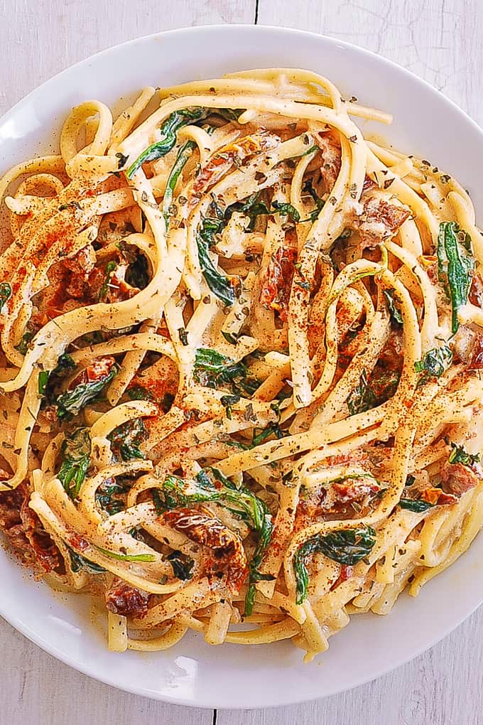linguine with spinach and sun-dried tomato cream sauce on a plate