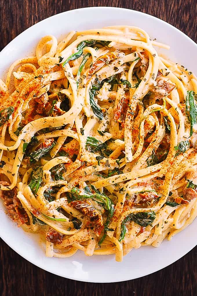 linguine with spinach and sun-dried tomato cream sauce on a plate