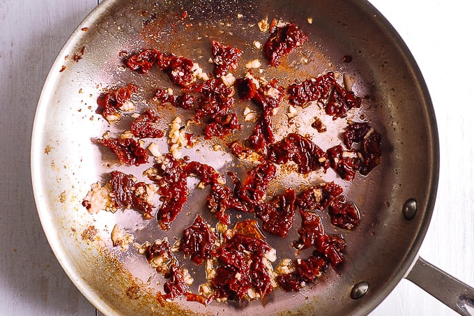 minced garlic and chopped sun-dried tomatoes in a skillet