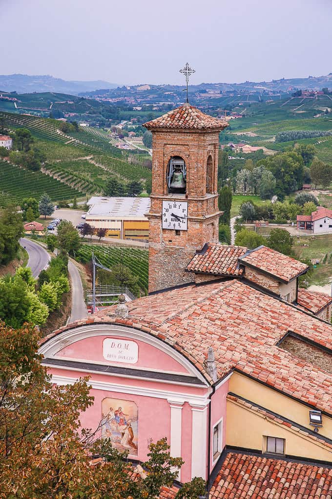 View from above of a building with a tower and wineries in the background in Barolo, Piedmont