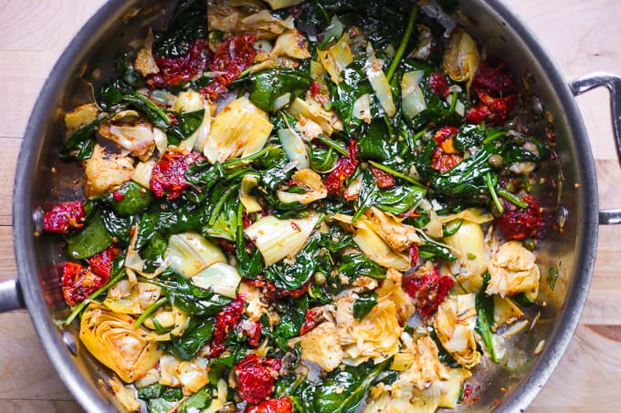 Wilted spinach with other veggies in a skillet